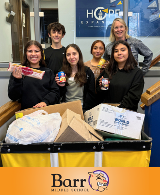  Barr NJHS Leaders smiling with Denise Pedersen at Hope Harbor with a crate of donated goods.