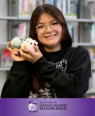  Esther Silva, GISH Senior, smiling with her crochet characters in the GISH Media Center.