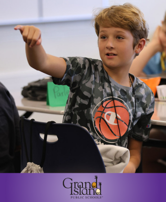  Middle School student raising hand in classroom on first day of school.