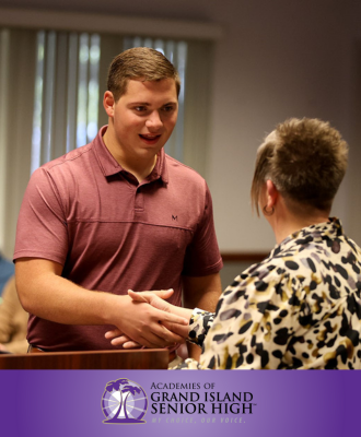  Owen Williams shaking hands with GIPS Associate Superintendent, Summer Stephens. 