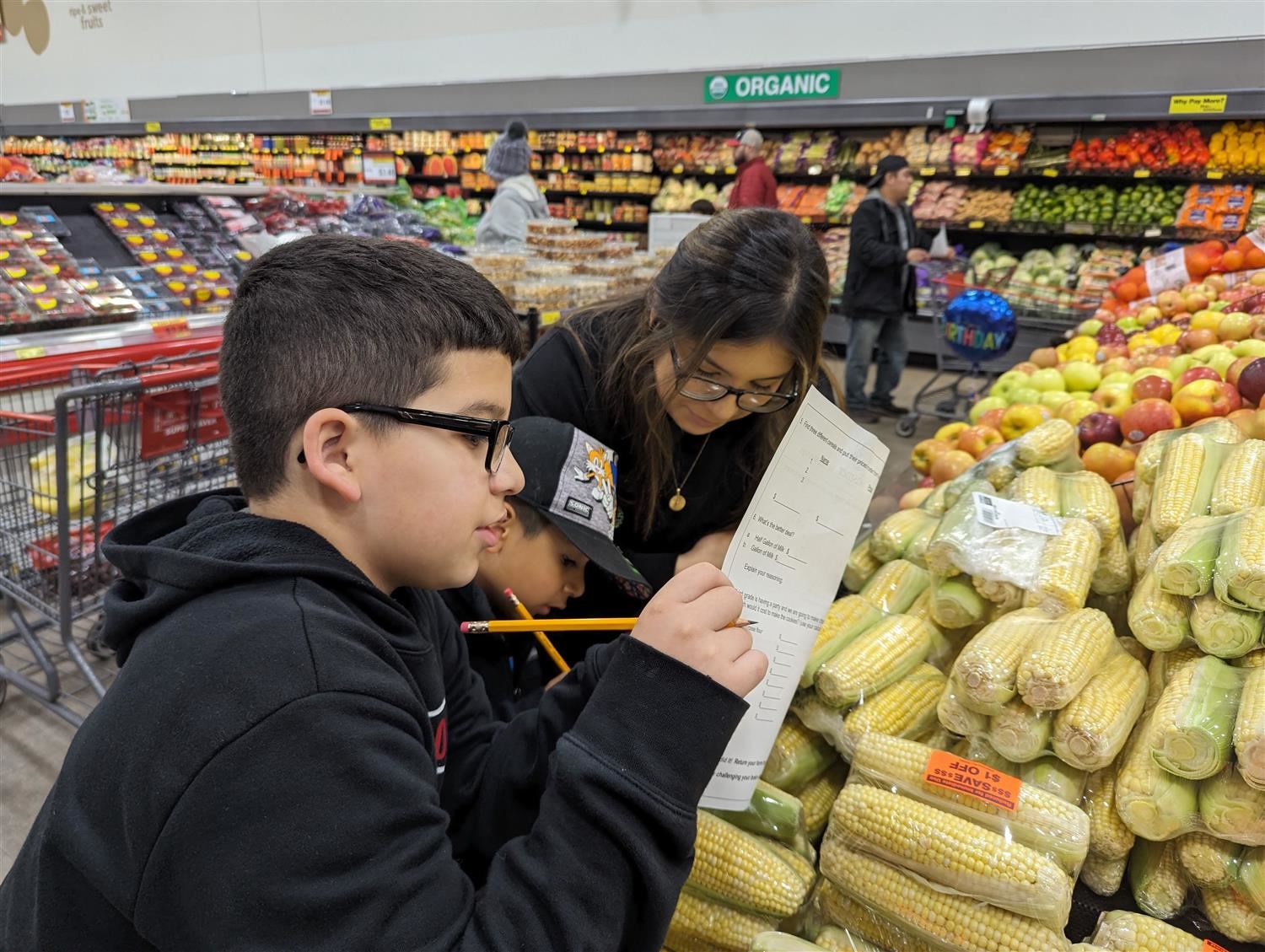 Wasmer family working on math problems with bananas at Super Saver.